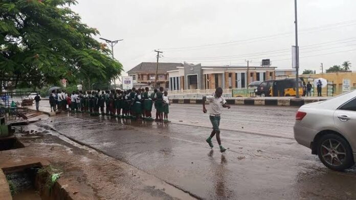 School children wait under heavy rain during Tinubu’s condolence visit to Benue